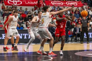 Dylan Ennis saca el balón de la pintura con Bozic y Paulí muy cerca de él. Fuente: La Verdad vía web
