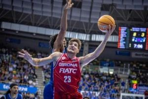 Sergi Martínez esquiva a un jugador del San Pablo Burgos para meter una canasta. Fuente: Básquet Girona web